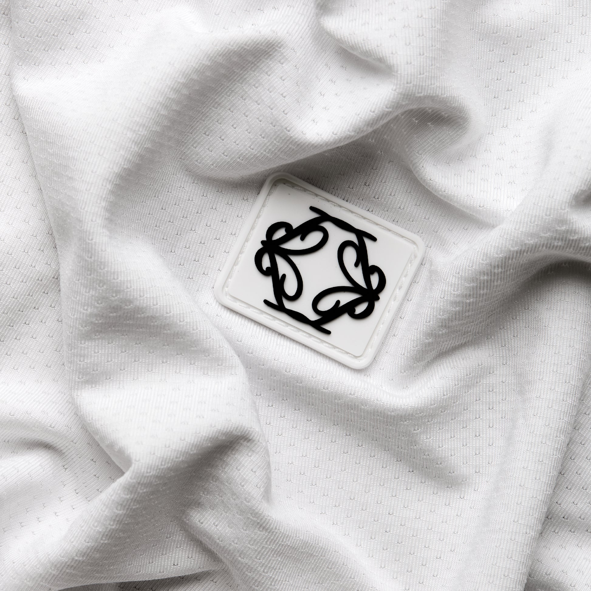 White fabric with a black embroidered design on a white background